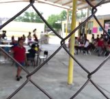 Infantes toman clases en el patio de la escuela